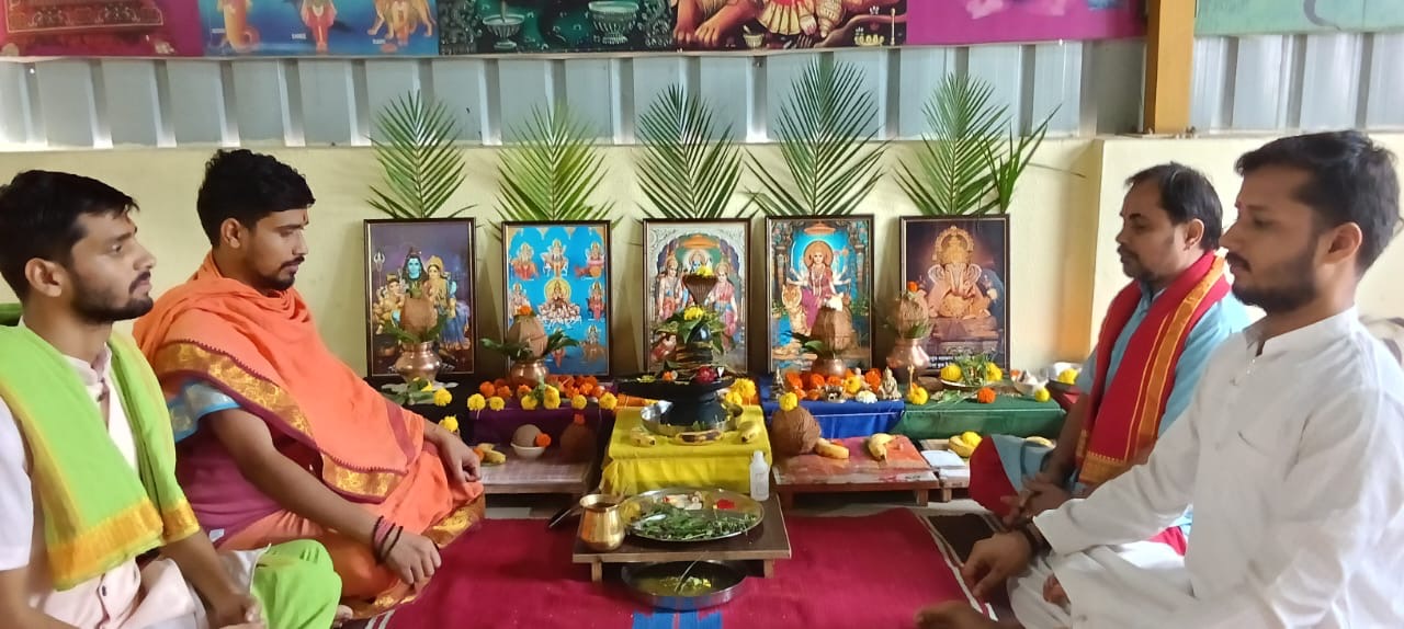 Pandits performing Shivling abhishek with deity images and offerings