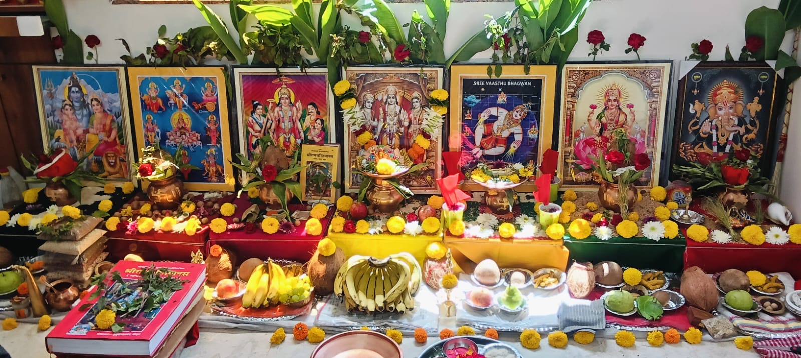 Vastu shanti puja setup with deity frames, kalash and offerings